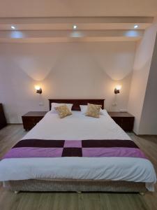 - une chambre avec un grand lit et 2 tables de chevet dans l'établissement DaMus apartments, à Erevan