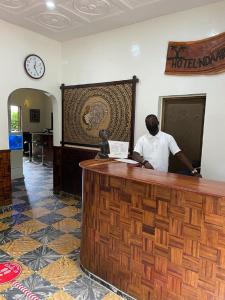 a man standing at a reception counter at a hotel room at Ndaary Khassoum in Ziguinchor