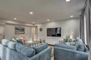 sala de estar con 2 sofás azules y TV de pantalla plana en Cozy West Palm Beach Condo 1 Block to Shore!, en West Palm Beach