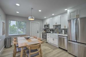 a kitchen with a table and a refrigerator at Cozy West Palm Beach Condo 1 Block to Shore! in West Palm Beach