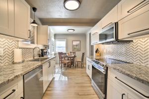 uma cozinha com armários brancos e uma sala de jantar em Chic Reno Home with Game Room and Putting Green! em Reno
