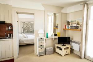Habitación pequeña con cama y TV. en Charmant appartement pour un sejour pour 4 a la Flotte en La Flotte