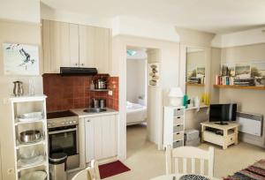 a small kitchen with white cabinets and a television at Charmant appartement pour un sejour pour 4 a la Flotte in La Flotte