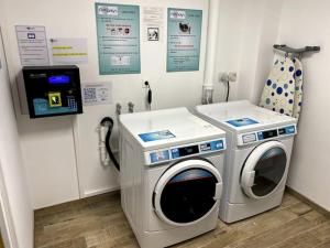 a laundry room with a washing machine and a phone at Villa Raphaëlle #1 Centre ville avec parking in Le Havre