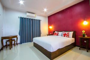 a bedroom with a bed and a purple wall at Mana Hotel in Chiang Rai