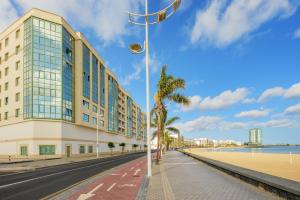 a building on the beach next to the ocean at Lanzahost Oceanis XXI in Arrecife