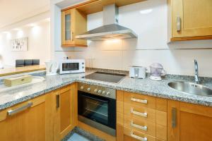 a kitchen with a sink and a stove top oven at Lanzahost Oceanis XXI in Arrecife