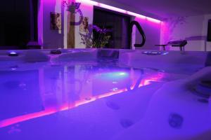 a bathroom with a tub with purple lights at Le Bonheur à la Campagne in Lesmont +65 photos