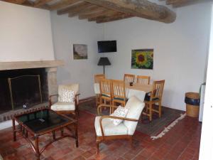 sala de estar con mesa, sillas y chimenea en Charmante maison, en Grand Bailly