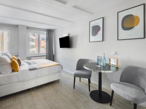 um quarto com uma cama, uma mesa e cadeiras em numa I Blau Apartments em Frankfurt