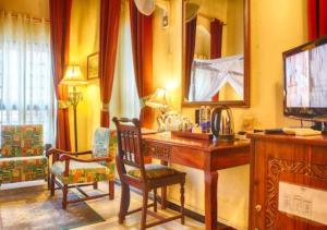Ngambo的住宿－Africa House Zanzibar，客房设有书桌、镜子和椅子。