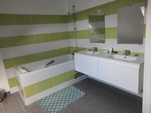 a bathroom with two sinks and a bath tub at La bellangerie in Joue-les-Tours