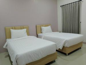 - deux lits assis l'un à côté de l'autre dans une pièce dans l'établissement อาม่า อพาร์ทเมนต์ Ama Apartment, à Ban Phai