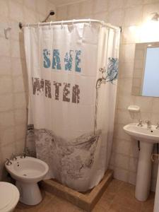 a bathroom with a shower curtain with the words save water at Apart Estepa in El Calafate