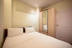 奈漢海灘的住宿－熱帶美景拉戈公寓酒店，一间卧室配有一张带白色床单和镜子的床