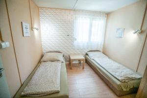 mały pokój z 2 łóżkami i oknem w obiekcie Rózsa Villa Vadkerti tó w mieście Soltvadkert