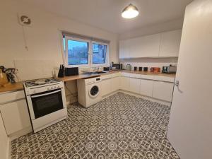 a kitchen with a stove and a washing machine at Harden Place in Wilton