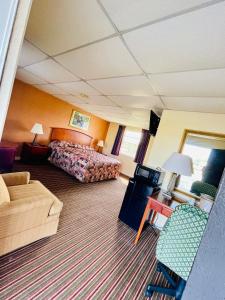 um quarto de hotel com uma cama e um sofá em Deluxe inn em Wilson