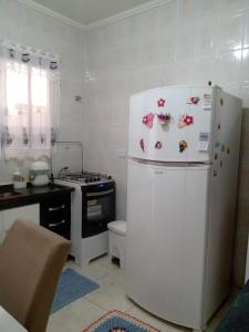 eine Küche mit einem Kühlschrank, an dem Magnete befestigt sind in der Unterkunft Casa de Férias in Guarujá