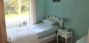 1 dormitorio con cama y ventana en Hollybanks, en Moycullen