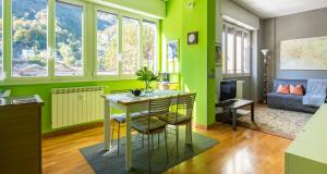 uma sala de estar com paredes verdes e uma mesa e cadeiras em JOIVY Vibrant Studio Near Train Station em Como