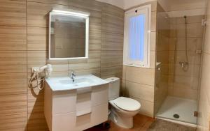 Un baño con inodoro, lavabo y ducha. en VIANYMAR APARTAMENTOS, en El Médano 29 fotos más