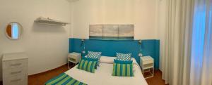 Un dormitorio con una cama azul y blanca con almohadas en VIANYMAR APARTAMENTOS, en El Médano