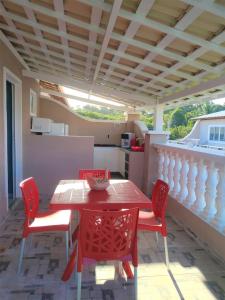 una mesa roja y sillas en un patio en EcoFlat Fiore II, en Paripueira