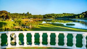 a view of a lake with a white railing at EcoFlat Fiore II in Paripueira