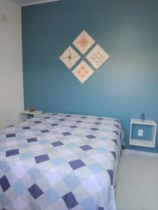 um quarto com uma cama com uma parede azul em EcoFlat Fiore II em Paripueira
