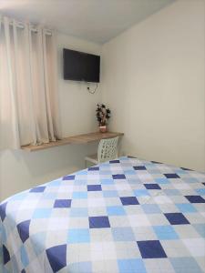 1 dormitorio con 1 cama blanca y azul a cuadros en EcoFlat Fiore II, en Paripueira