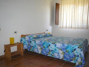 1 dormitorio con 1 cama con colcha de flores azul en Podere Valmarina, en Follonica