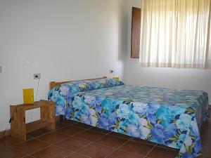 a bedroom with a bed with a blue floral bedspread at Podere Valmarina in Follonica