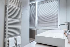 ミュンスターにあるLuxuriöses Loft über den Dächern Münsters 150 m²の白い洗面台と窓のあるバスルーム +40枚の写真