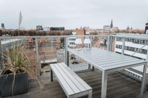 d'une table et d'un banc blancs sur un balcon. dans l'établissement Luxuriöses Loft über den Dächern Münsters 150 m², à Münster