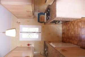 una pequeña cocina con fregadero y ventana en Villa Isabel, en Son Bou
