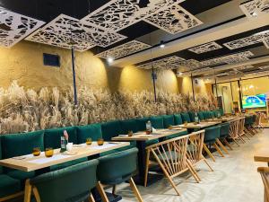 a dining room with tables and green chairs at AVO Hotel in Rîmnicu Sărat