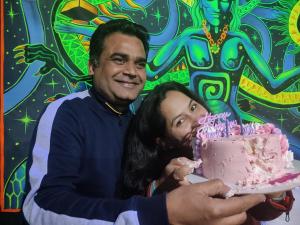un hombre y una mujer sosteniendo un pastel de cumpleaños rosa en Dream Valley Home Stay en Kasol