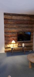 een grote houten muur met een flatscreen-tv bij Polaris Homes Huippu in Syöte