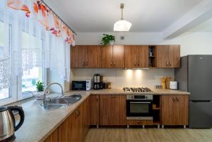 a kitchen with wooden cabinets and a stainless steel refrigerator at Pokoje Pod Brzózką in Dębno