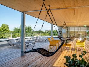 a swing on the deck of a house at Hotel FrechDachs in Bad Füssing