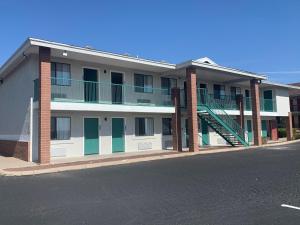 - un bâtiment avec des portes et des escaliers verts dans une rue dans l'établissement GreenTree Inn of Holbrook, AZ, à Holbrook
