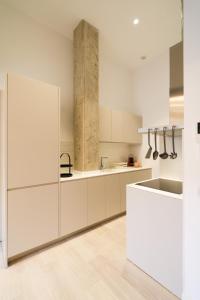 a white kitchen with white cabinets and a sink at UrBaN ArT Historic Center @Mellow in Málaga +23 photos