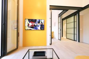 a living room with a yellow wall and a glass table at UrBaN ArT Historic Center @Mellow in Málaga
