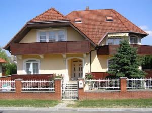 a house with a red roof and a white fence at Jakab Ház in Hévíz