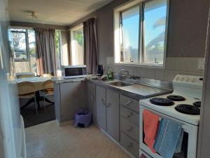a kitchen with a sink and a stove top oven at Mount Budget Accommodation in Tauranga
