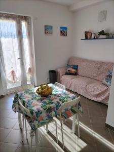 een woonkamer met een tafel en een bank bij Green House in Cogoleto