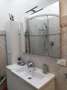 a bathroom with a sink and a shower with a mirror at Green House in Cogoleto