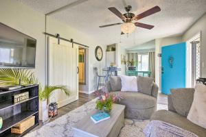 uma sala de estar com um sofá e uma ventoinha de tecto em Sunny Central Condo Lanai and Community Pool Access em Kailua-Kona