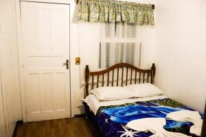 Un dormitorio con una cama y una ventana y una puerta. en Pousada Tia Leonor, en Gramado